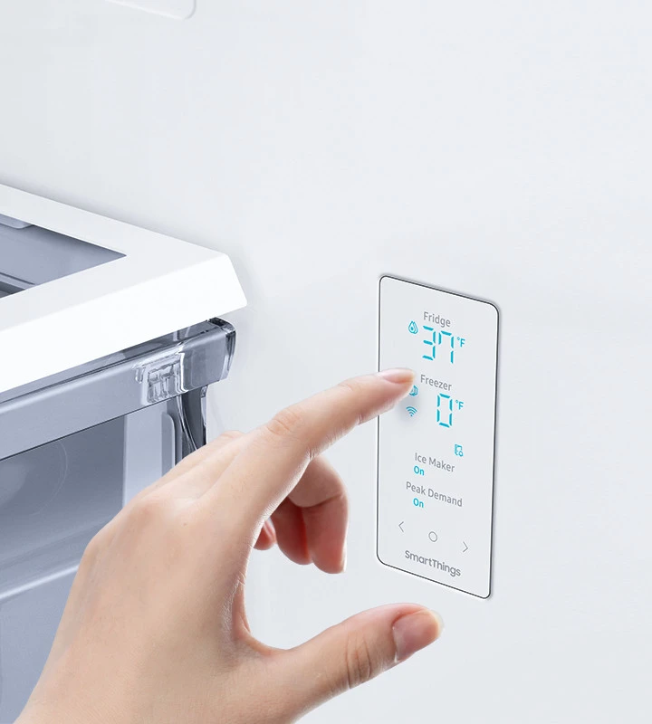 Person setting fridge temperature on refrigerator control panel