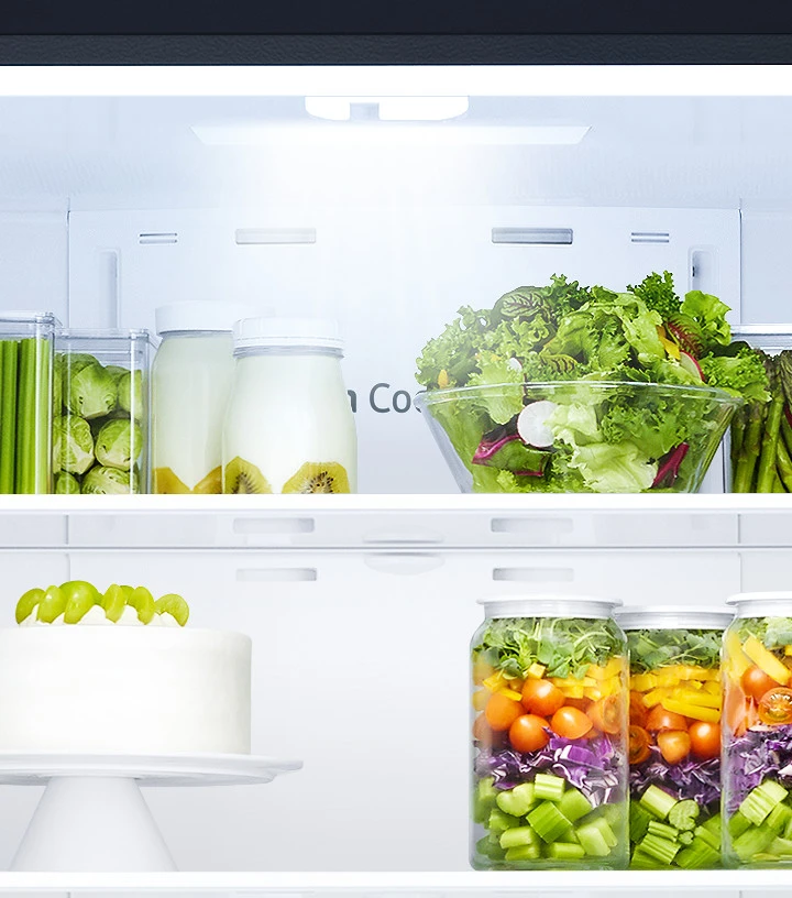 Counter depth refrigerator shelves storing fruits, vegetables and cake